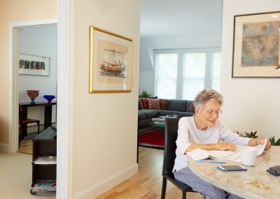 Senior resident enjoys coffee at in her home at Newton, MA's high end independent living community Lasell Village.